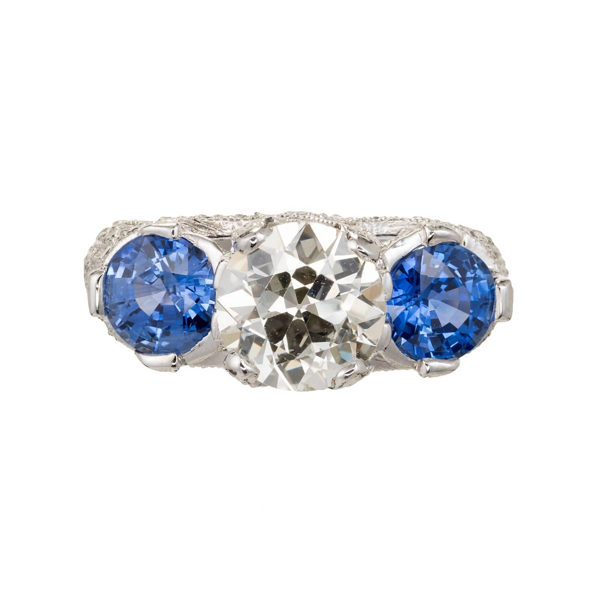 Peter Suchy three-stone diamond and sapphire engagement ring.  The center diamond is a sparkly, circular brilliant cut GIA certified #2175591686. The sapphires are also circular brilliant cut with great sparkle as well. simple heat natural. The