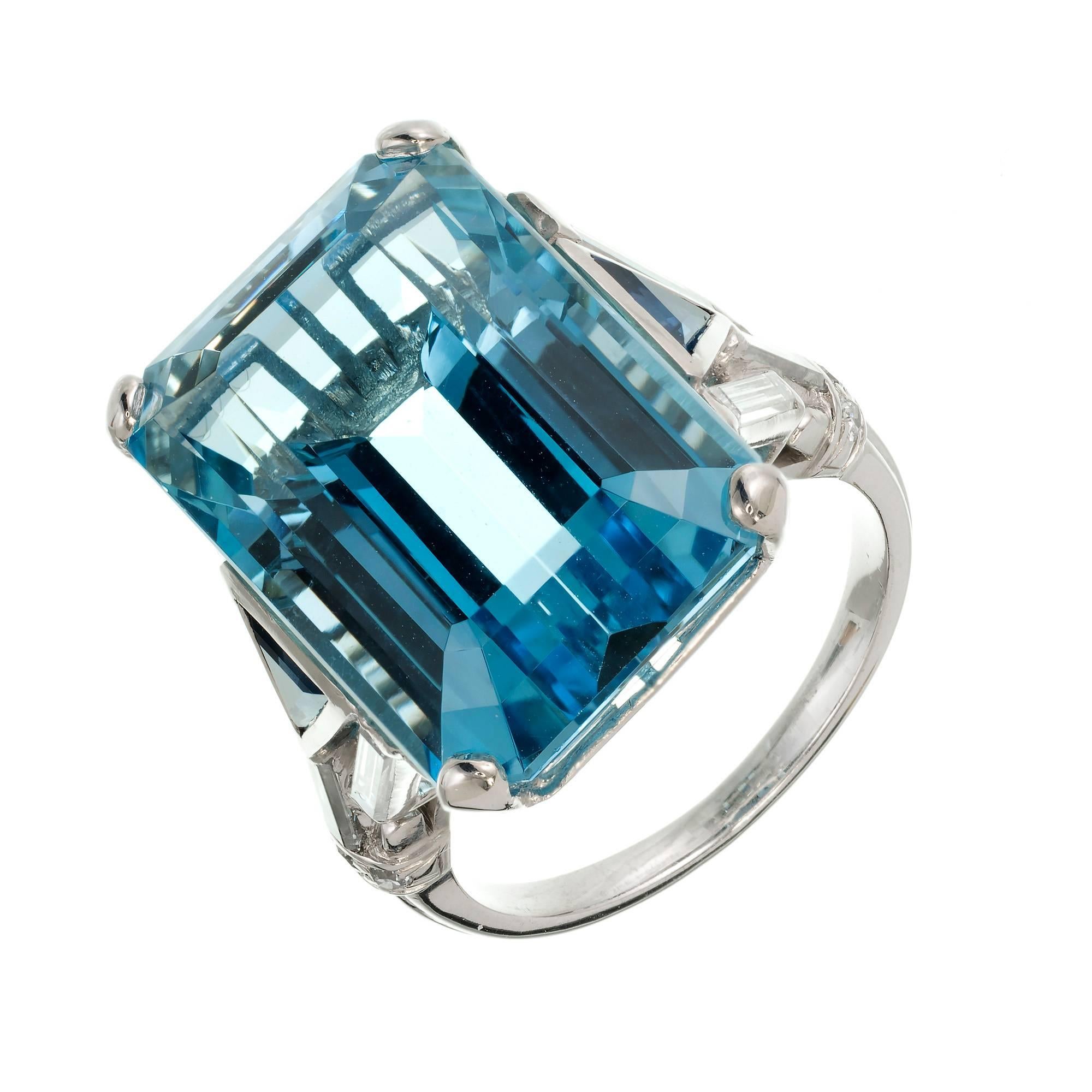 1950s aqua diamond and sapphire cocktail ring. Natural bright blue Aqua 18.87cts with triangle Sapphires and long straight baguette Diamond accents in a solid Platinum setting.

1 Emerald cut gem blue Aquamarine, approx. total weight 18.87cts, VS
2