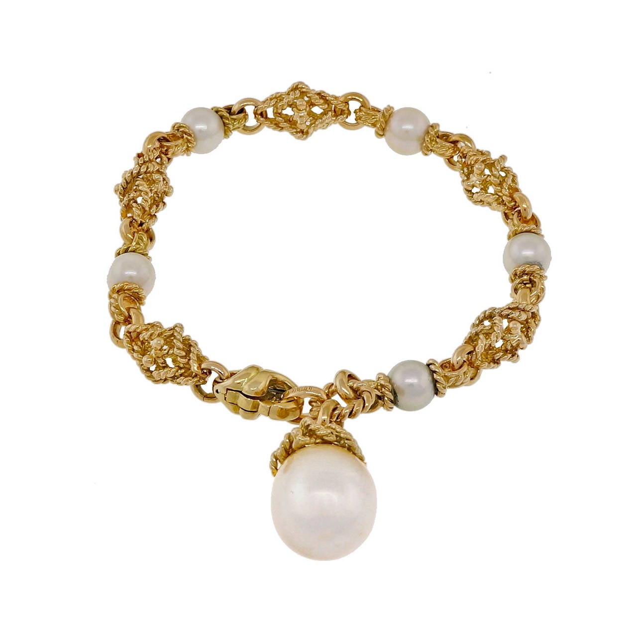 Solid 18k yellow gold 3 dimensional textured link bracelet with a South Sea pearl dangle and pearls throughout. Circa 1960. See our matching necklace.

5 Japanese culture pearls 6.5 – 7mm
1 South Sea pearl 14.75 x 12.75mm
18k yellow gold
27.7