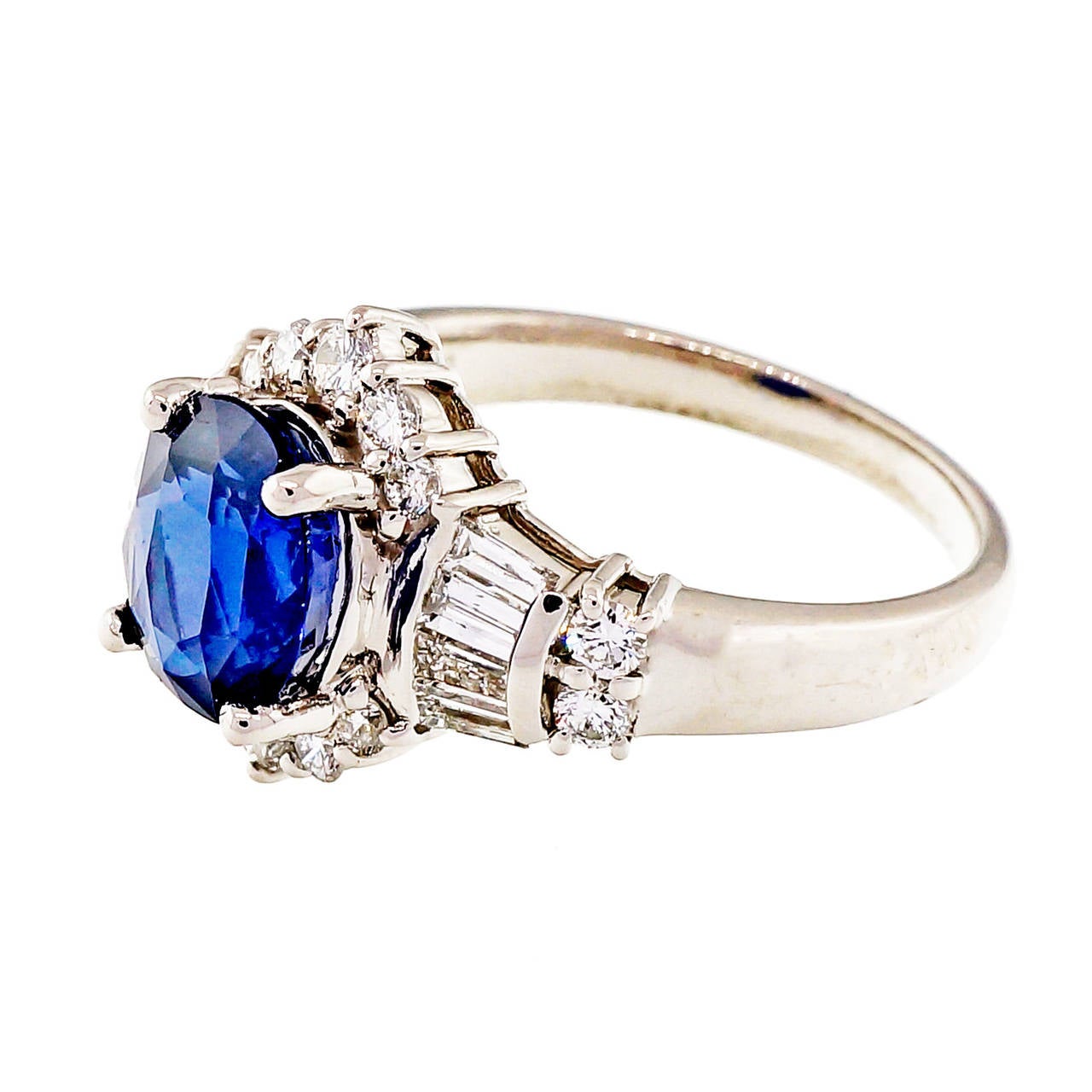 Beautiful bright pure blue oval Sapphire in a handmade Platinum setting. Top quality diamonds. Sapphire appears to be an older cut. Top gem blue cornflower color and very bright internally, VS clarity. GIA certified as simple heat only. The ring
