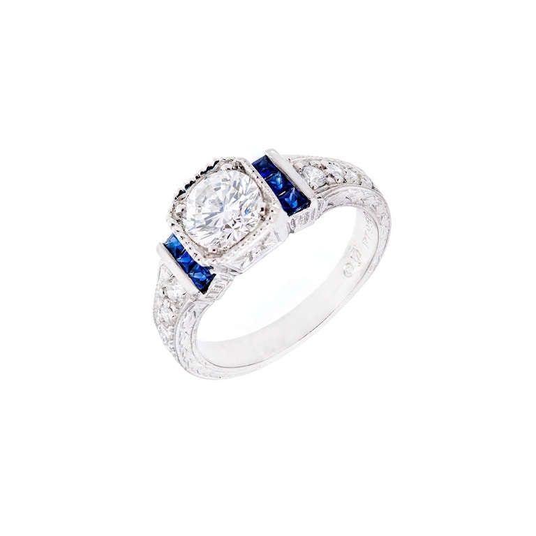 8 sided top with a beautiful GIA certified sparkly fine white Ideal cut diamond engagement ring. Square Sapphires and round diamond accents. Hand engraved sides and shoulders.  

1 round brilliant cut Ideal cut diamond, approx. total weight 1.00cts,