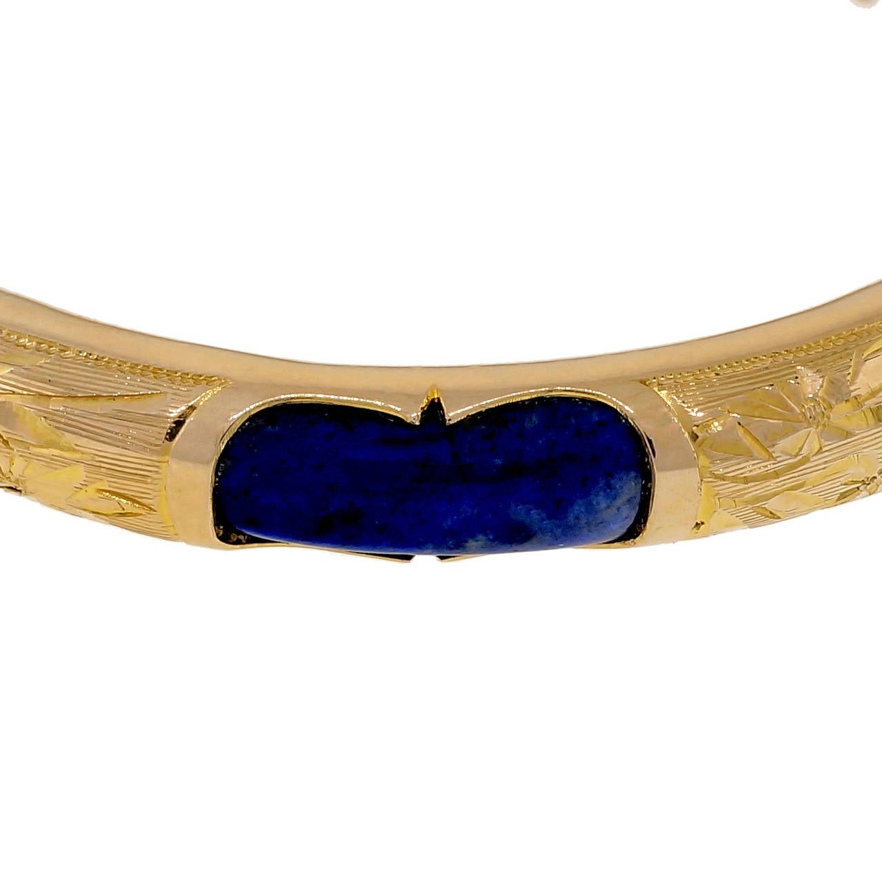 Handmade Lapis 14k yellow gold bangle bracelet. Natural untreated bright blue Lapis with Iron Pyrite. Secure catch hinge. Hand engraved between Lapis sections.

6 bright blue Lapis, 16.64 x 6.20mm, blue, natural untreated with iron Pyrite
14k yellow