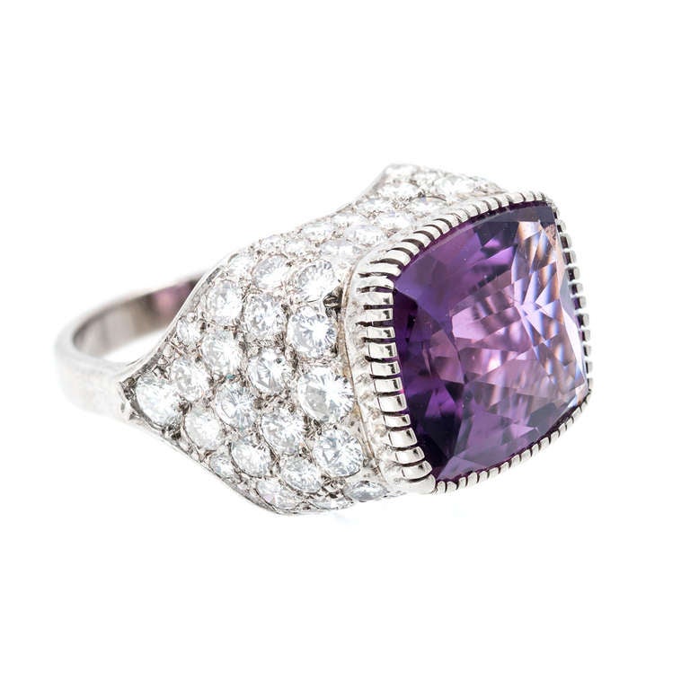 Circa 1950 antique cushion shape Amethyst with a cascading down fall of bright diamonds set in an 18k white gold dome shaped ring setting.  

82 round diamonds approx. total weight 3.85cts, G, VS-SI The Amethyst measures 17 by 14mm.The width of the