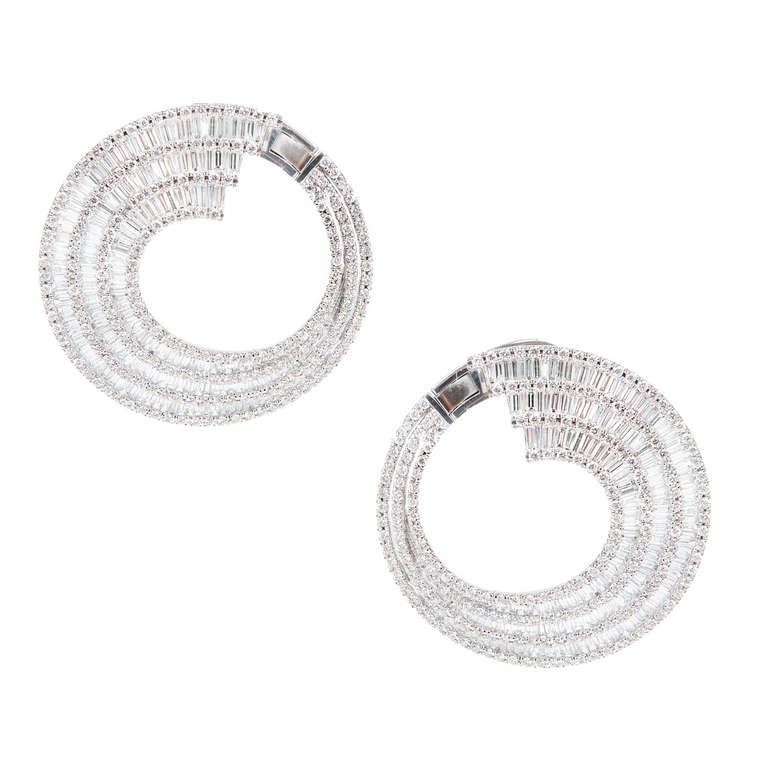 1960s Wrap around round and baguette Diamond hoop clip post earrings.

18k White gold
412 round full cut diamonds, approx. total weight 6.00cts, G, VS2
399 Baguette tapered diamonds, approx. total weight 4.50cts, G, VS-SI
Top to bottom: 42.03mm or