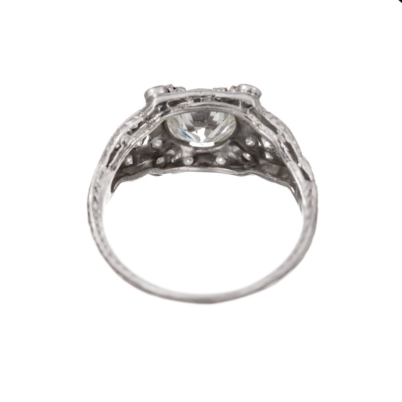 Circa 1960 transitional cut diamond in a handmade open work platinum setting with accent diamonds.

1 transitional brilliant cut Ideal diamond, approx. total weight 1.35cts, H-I, SI2, Depth: 54% Table: 57%, 7.47 x 7.31 x 3.99mm, eye clean.
22 single