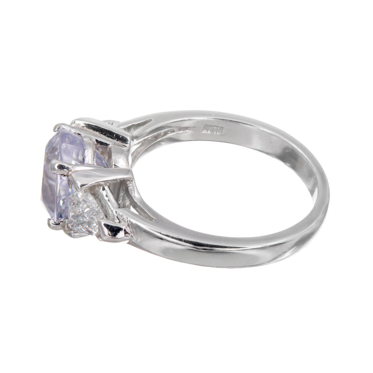 Natural Sapphire and diamond three-stone engagement ring. Light purple sapphire center stone set in plaitnum with two trilliant cut side diamonds. 

1 oval very light purple natural Sapphire, approx. total weight 3.25cts, VS, simple heat only no