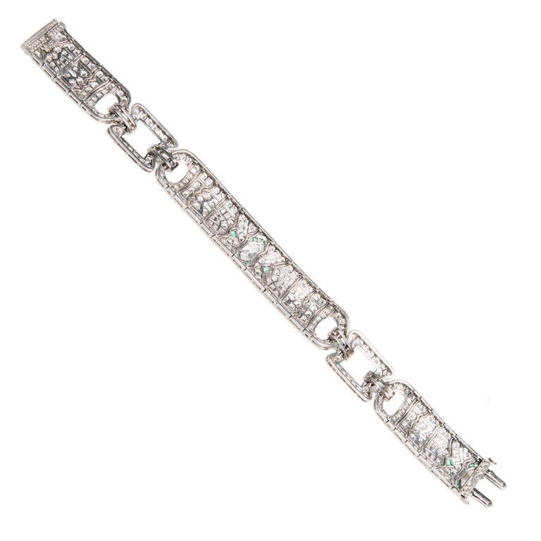 Solid hand made Platinum diamond and emerald bracelet with repeating large and small Deco sections and a hidden catch. 

2 Marquise diamonds approx. total weight 1.50cts, G, VS. 
264 round diamonds approx. total weight 7.00cts, F, VS1-SI1. 
28