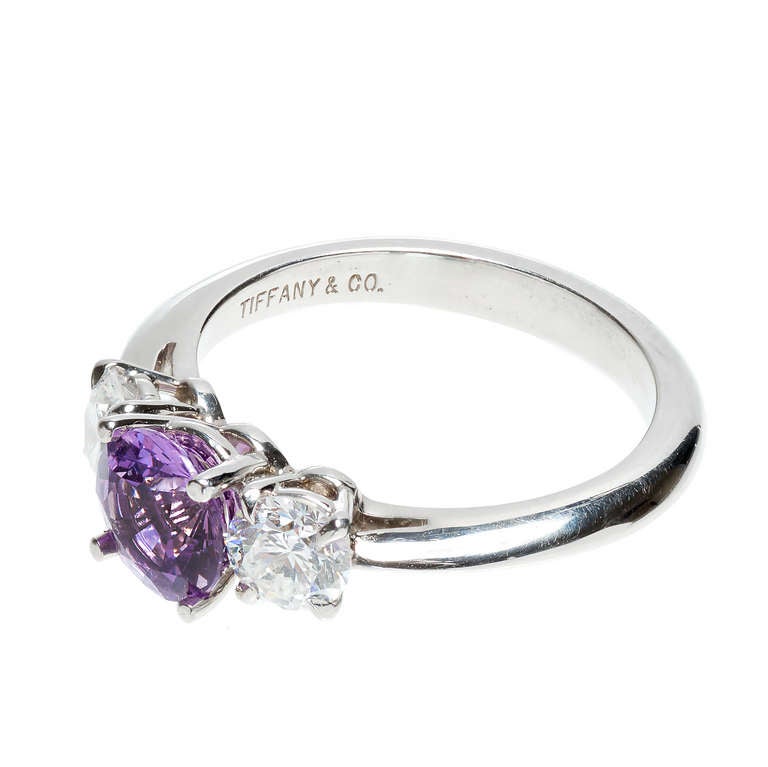 Tiffany & Co 1.22ct three stone purple sapphire engagement ring with white Ideal cut side diamonds in a platinum setting. GIA certified all natural no heat pinkish purple center round Sapphire. Stamped Tiffany. Circa 1980-1990. 

1 round pinkish