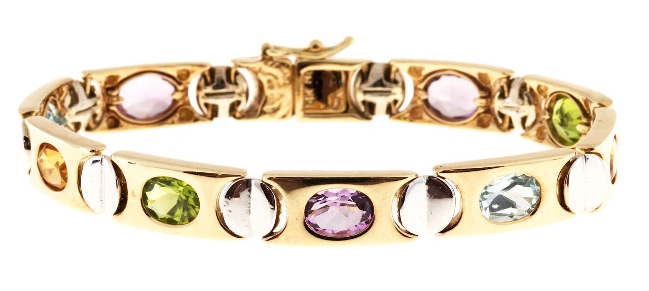 Nice heavy 14k two tone multi oval stone bracelet. Bezel set yellow gold links with white gold screw head design connectors. Hidden catch. Side lock safety.

2 oval blue Topaz approx. total weight 2.20cts, 7mm. 3 oval Amethyst approx. total weight