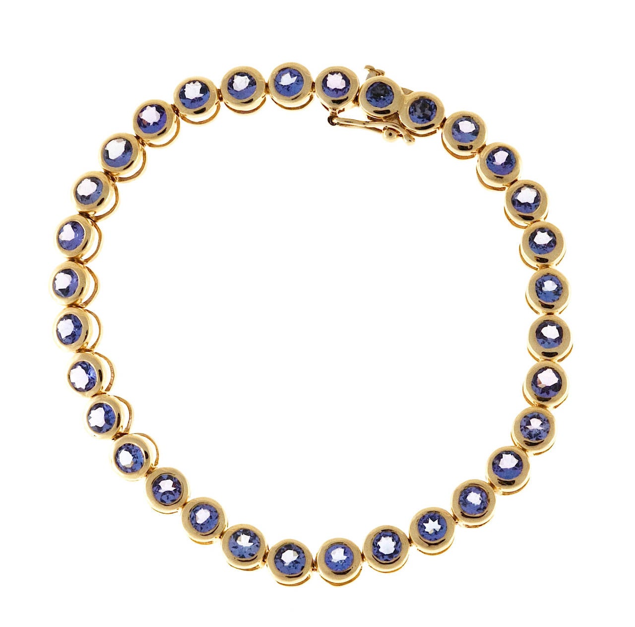 Bezel set 14k gold STS bracelet with 32 medium bright blue Tanzanite approx. 4.00ct total. Built in hidden catch.

32 3mm round medium purple Tanzanite approx. total weight 4.00ct
14k Yellow Gold
Stamped: 14k STS
10.9 grams
Width: