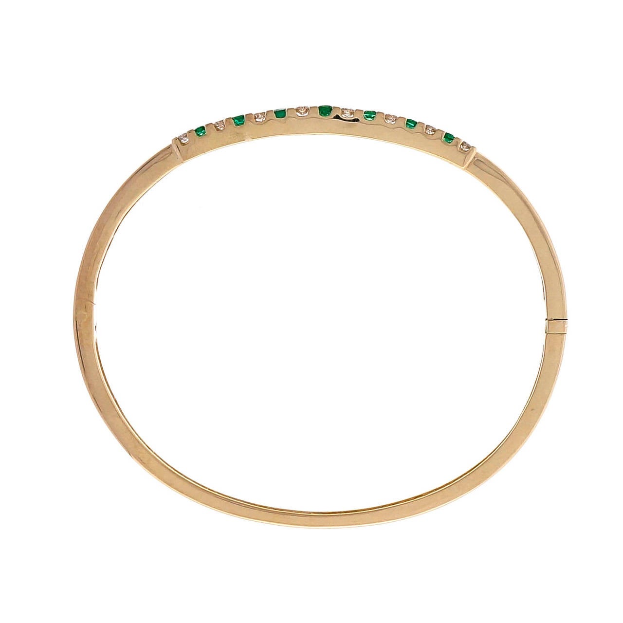 Oval hinged CEI 14k yellow gold bangle bracelet with alternating fine Emerald and diamond graduate top.

24 round diamonds, approx. total weight .50cts, G, SI1
21 round fine green Emeralds, approx. total weight .48cts, SI
14k yellow gold
16.7