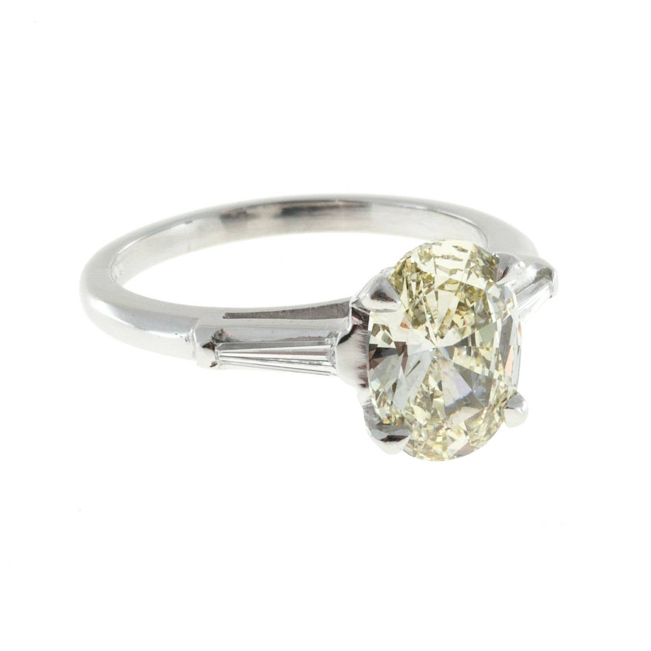 Bright fancy light yellow oval diamond in a classic baguette Platinum ring.

1 GIA certified# 2135723862 oval diamond, approx. total weight 1.72cts natural fancy light yellow, VVS2 clarity, 9.68 x 7.21 x 3.84mm, bright and sparkly
2 tapered