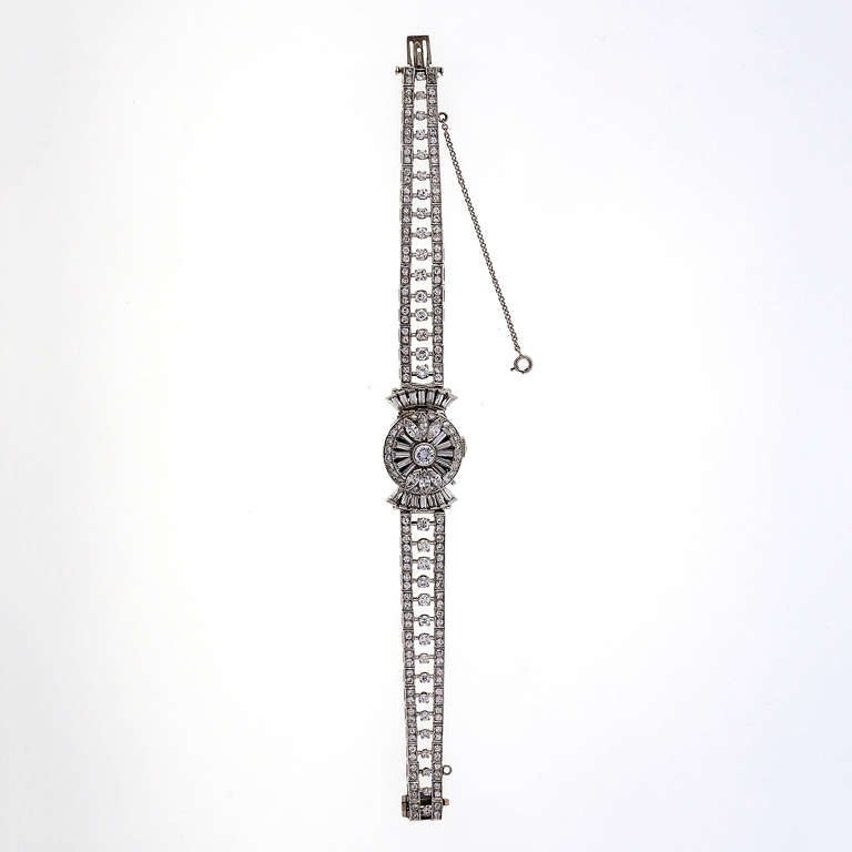 Hamilton lady's platinum and diamond bracelet watch with concealed dial, retailed by Tiffany & Co., circa 1950s. The dial cover is designed with round Marquise and baguette diamonds. The bracelet is all round full cut diamonds. Approx 5.16 cts total