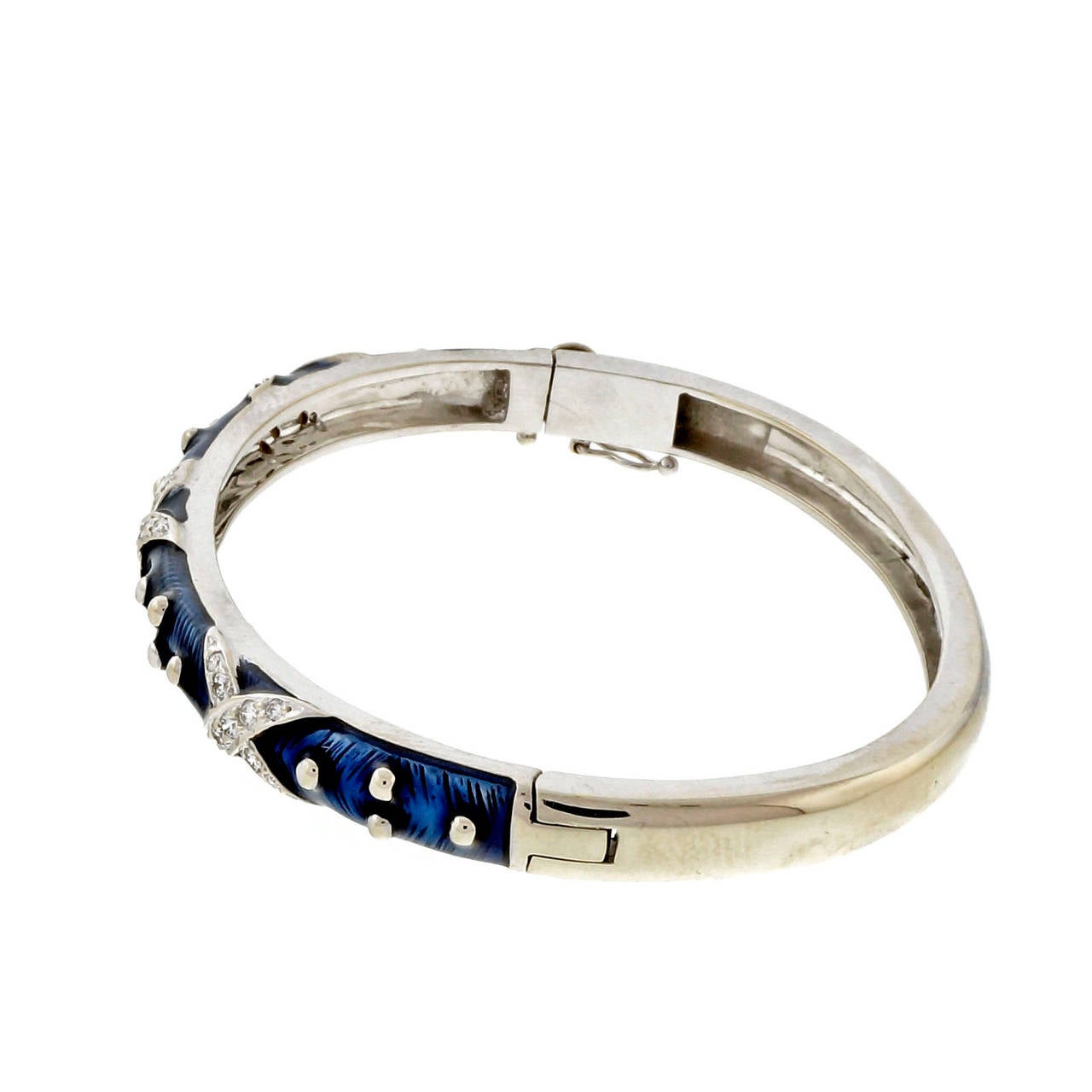 Hidalgo 18k white gold blue enamel “XX” design diamond hinged bangle bracelet. No damage to enamel.

27 round diamonds, approx. total weight .75cts, H, VS – SI
18k white gold
Tested: 18k
Stamped: 750
Hallmark: Hidalgo
23.9 grams
Width: