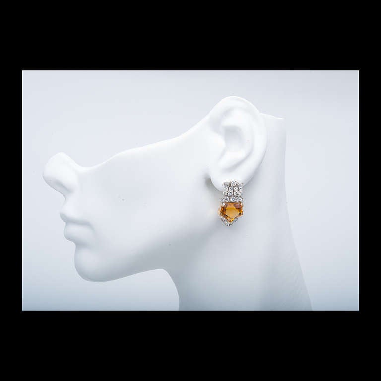 Retro 1940 to 1950 bright orange Citrine yellow and white gold earrings with vivid orange Citrines.  Looks great on the ear.

14k White gold 
19 round mixed cut diamonds, approx. total weight 1.40cts, H, VS-SI
4 baguette cut diamonds, approx.