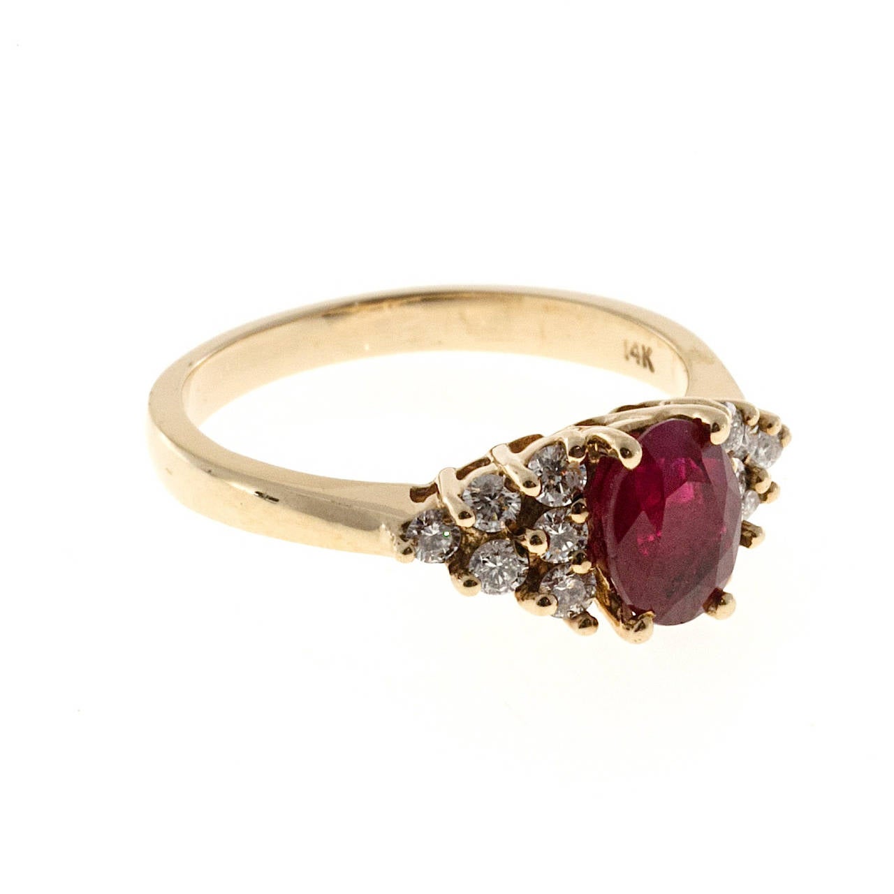 Classic style 14k yellow gold ring wire style top is set with a red brightly colored genuine ruby and six fine white full cut diamonds set in a triangular pattern on either side.

1 oval ruby approx. total weight .90cts
12 round diamonds approx.