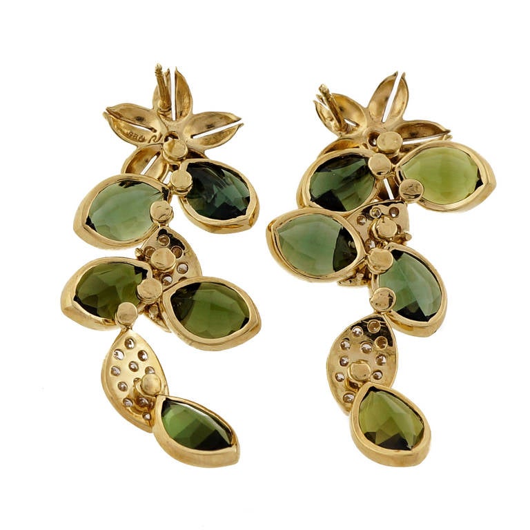 Totally handmade hinged section diamond pave and green Tourmaline faceted dangle earrings. Flower design. Looks great on the ear.

18k Yellow Gold
10 faceted Marquise genuine green Tourmaline, approx. total weight
12.00cts, VS
54 full cut round