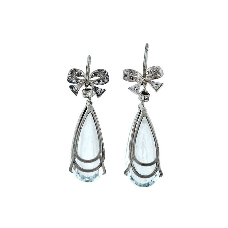 Exceptional 1940's 18k white gold diamond bow top dangle earrings with elongated backs natural no heat beautiful Aqua dangles.   

18k White gold & 14k backs
2 pear shaped natural slightly greenish blue Aqua, approx. total weight 11.50cts, VS,