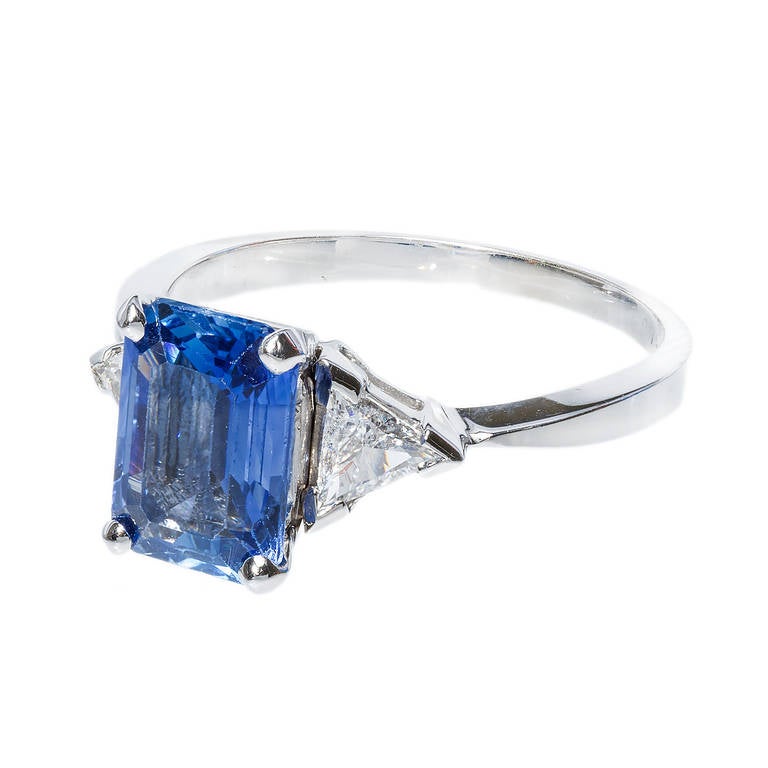 Bright blue Emerald cut Sapphire and trilliant cut diamonds in a white gold setting. GIA certified natural color simple heat only. 

1 Emerald cut bright blue Sapphire, approx. total weight 2.30cts, VS, natural Sapphire simple heat only, GIA