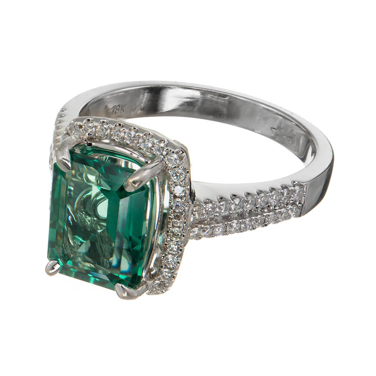 Estate bright green genuine Emerald cut Tourmaline with a hint of blue surrounded by bright white diamonds. Signed SB. Circa 1960-1970.

1 Emerald cut green Tourmaline, approx. total weight 3.10cts, 8.72 x 6.90mm
68 round full cut diamonds,