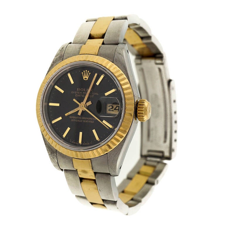 Ladies Steel and yellow gold Rolex with black dial, Oyster bracelet, circa 1987.

Stainless steel and 18k yellow gold 
Movement: Automatic, 2135, Rolex, 29 jewels, Adj 5 pos, 0689223 
Dial: Black baton 
Length: 6.25 inches 
Length: 33mm 
Width: 26mm
