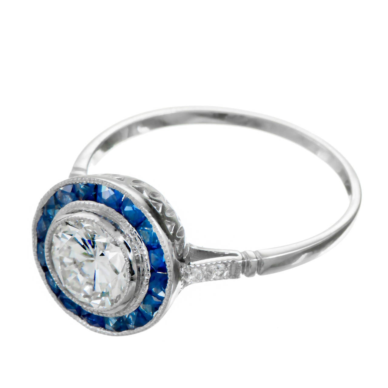 Bague de fiançailles en diamant et saphir. Diamant central de taille idéale européenne certifié par le GIA avec un halo de 16 saphirs de taille calibre dans une monture en platine avec des diamants de taille européenne de part et d'autre de la tige.