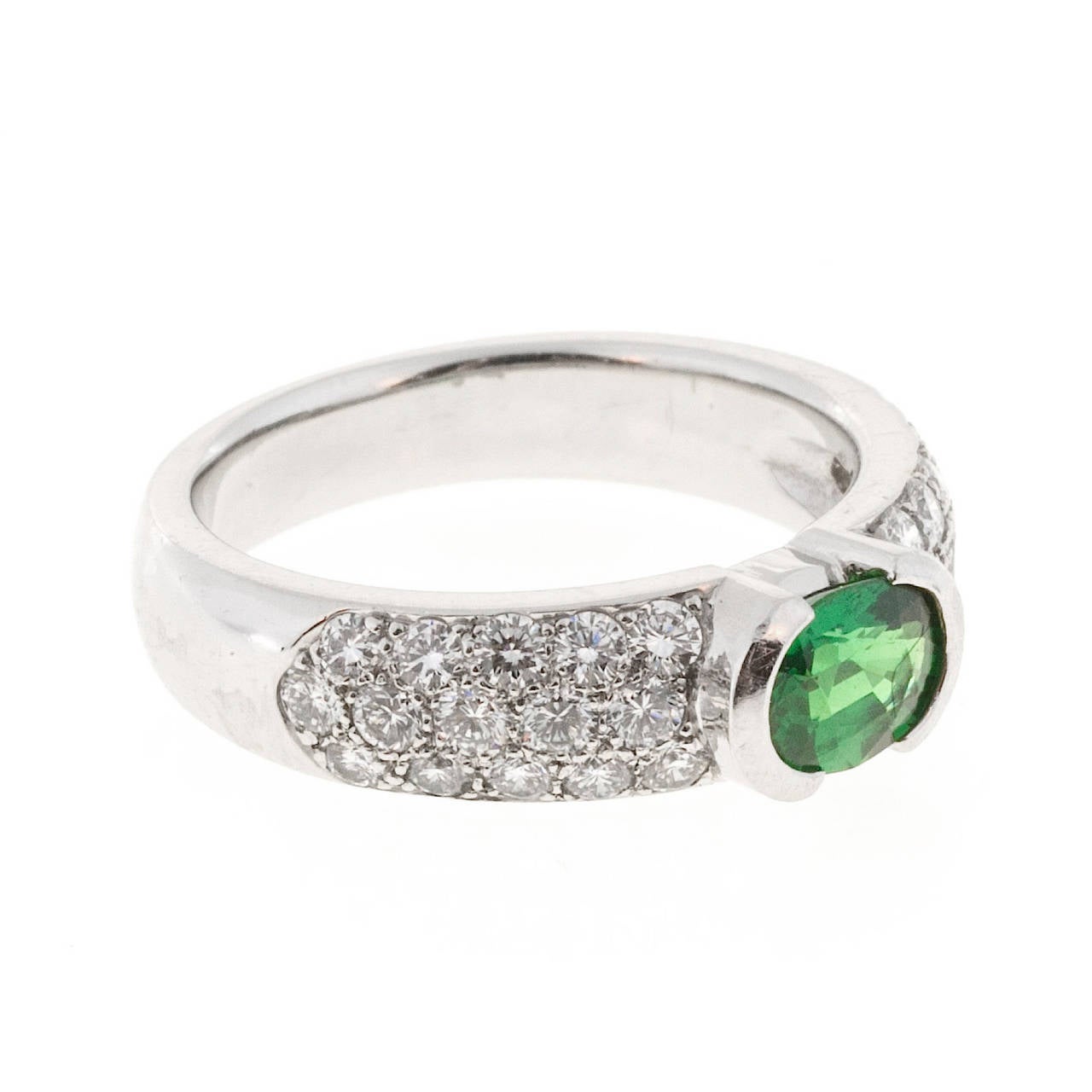 Fine top gem natural oval Tsavorite Garnet in a solid Platinum ring with semi bezel top and pave set sides.

1 oval gem Tsavorite Garnet 7 x 5mm, approx. total weight 1.00ct
30 full cut diamonds, approx. total weight .75cts, F,