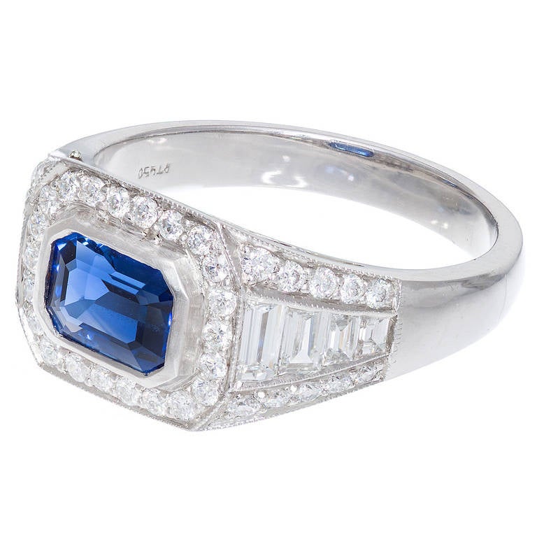 Handmade Art Deco 1920s emerald cut sapphire engagement ring.  in Platinum. 8 custom cut graduated baguette diamonds and round full cut diamonds in a platinum setting. Filigree top  and bottom rear gallery.  The center is set with a gem color bright