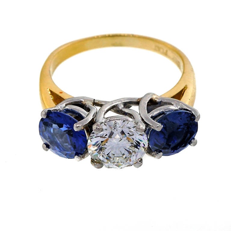 Incredibly bright  sparkly ring with an Ideal cut diamond certified as excellent cut H - white face up, I1, one small flaw under a prong and two full size bright cornflower blue Sapphires. Handmade Platinum and 18k setting.

1 round brilliant cut
