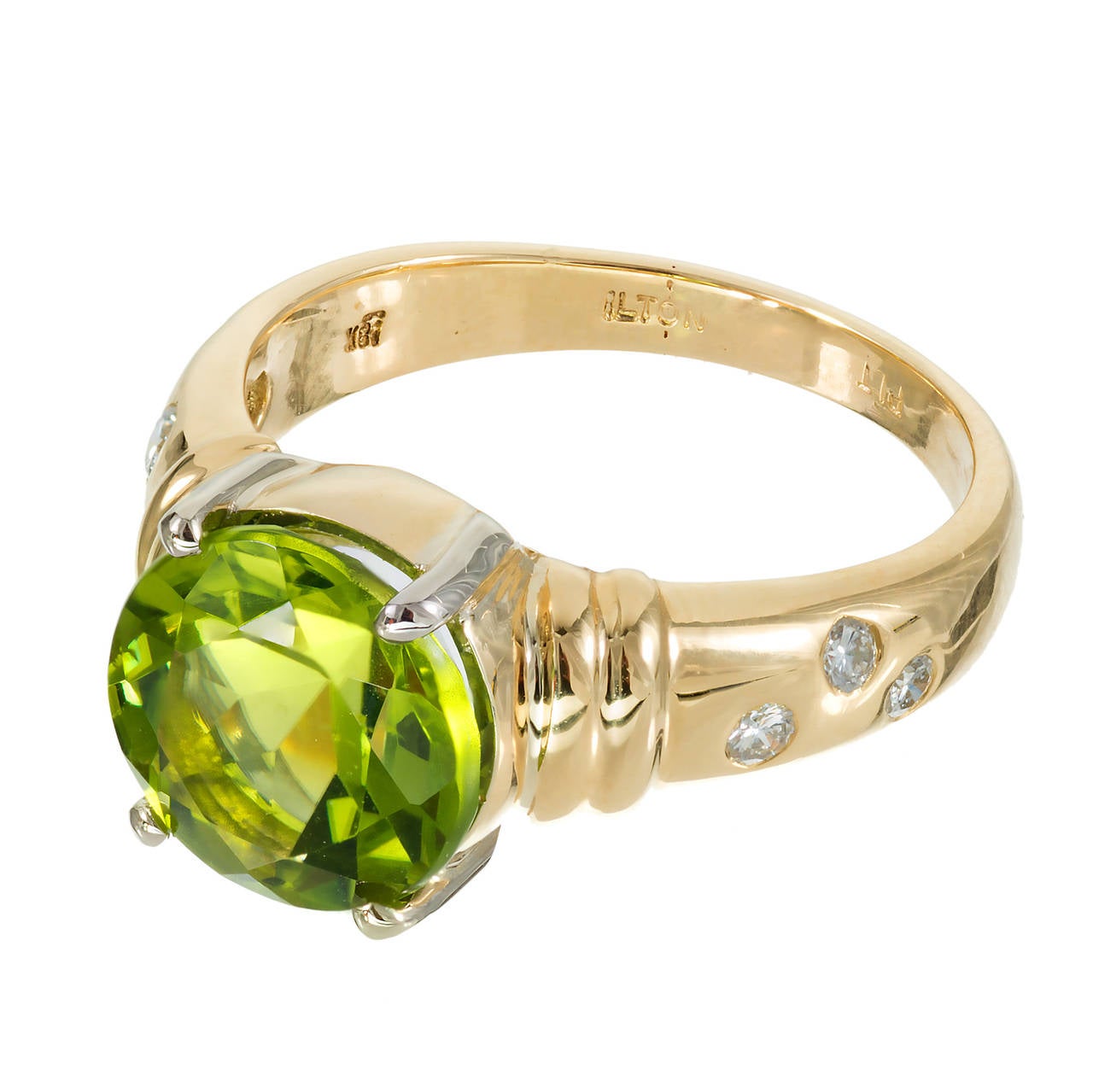 Bright and beautiful round Peridot ring signed Ilton with a 3.90ct Peridot in an 18k yellow gold setting with Platinum prongs and diamond shank.

1 round medium green Peridot, approx. total weight 3.90cts, VS
6 round full cut diamonds, approx. total