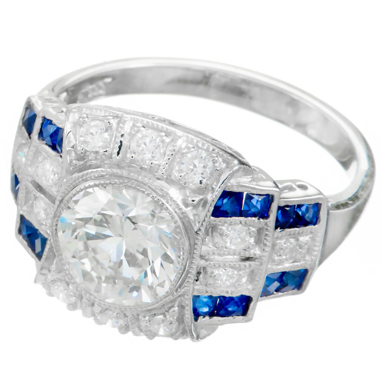 1940's Art Deco, diamond and sapphire engagement ring. Platinum setting with round center diamond and calibre cut Sapphires, accented by ideal cut round diamonds. Face up color I plus. Shows just a hint of warm color and lots of sparkle.

1 round
