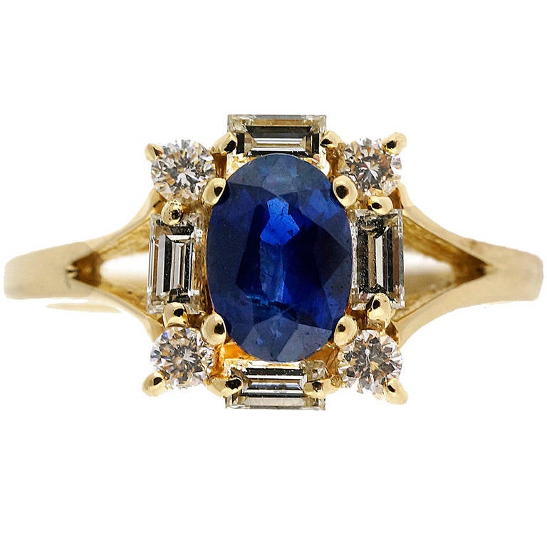 Oval cornflower blue Sapphire in a simple Halo ring with round and baguette diamonds accents in a 14k yellow gold setting.

1 oval cornflower blue Sapphire, approx. total weight .62cts
4 baguette diamonds, approx. total weight .20cts, G, VS
4 round