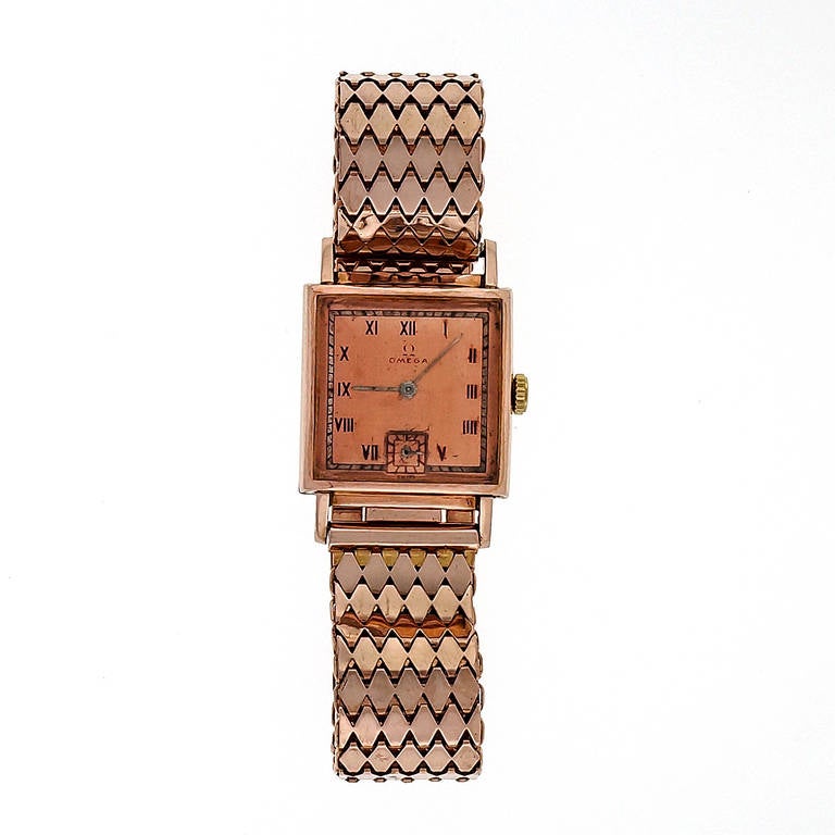 Omega 14k rose gold wristwatch with rose gold braelet. Original red Omega dial, circa 1940. 

14k rose gold
Bracelet Length: 7 inches
Bracelet width at case: 15mm
Top to bottom: 33mm
Width without crown: 23.36mm
Width with crown: 24mm
Case