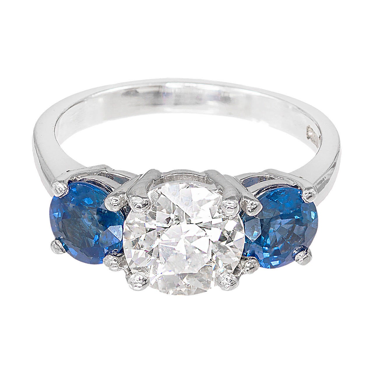 Three-stone diamond and sapphire engagement ring. European cut diamond of exceptional color and sparkle. Exceptional brilliance, raised crown and small table. Large diameter setting. The platinum setting is designed in the Peter Suchy Workshop to