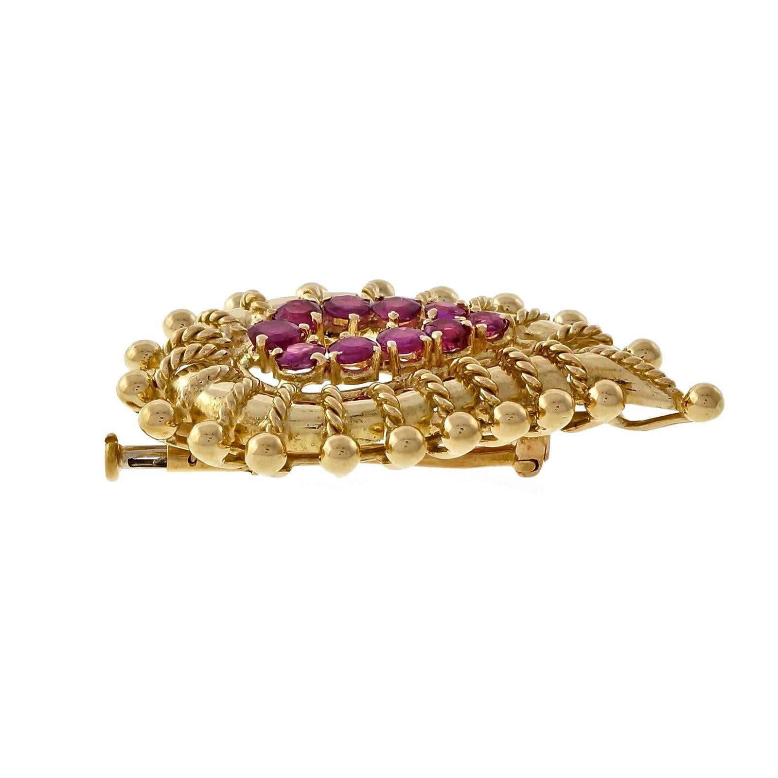 1960’s Tiffany & Co. round ruby solid 18k yellow gold brooch. 

10 round pinkish red Rubies, approx. total weight 1.60cts, MI
18k yellow gold
Tested and stamped: 18k
Hallmark: Tiffany Italy
10.1 grams
Top to bottom: 37.73mm or 1.49 inches
Width: