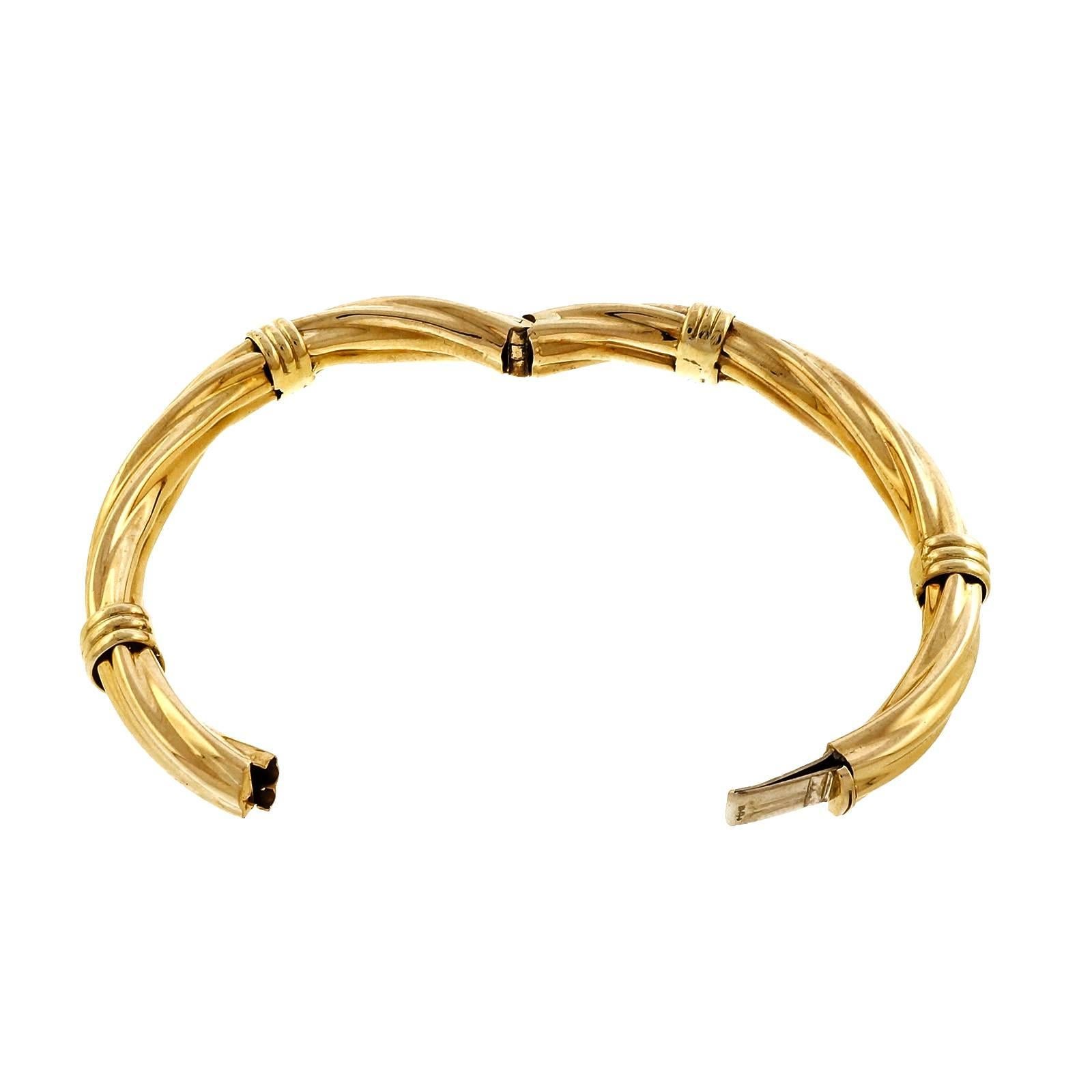 1970 18k gold 10mm wide twisted style hinged bangle bracelet with four triple band details.

18k yellow gold
27.3 grams
Tested: 18k
Stamped: 750
Hallmark: D with an arrow through it
Inside dimensions: 2.32 x 2.02 inches
Width: 10mm
Depth: