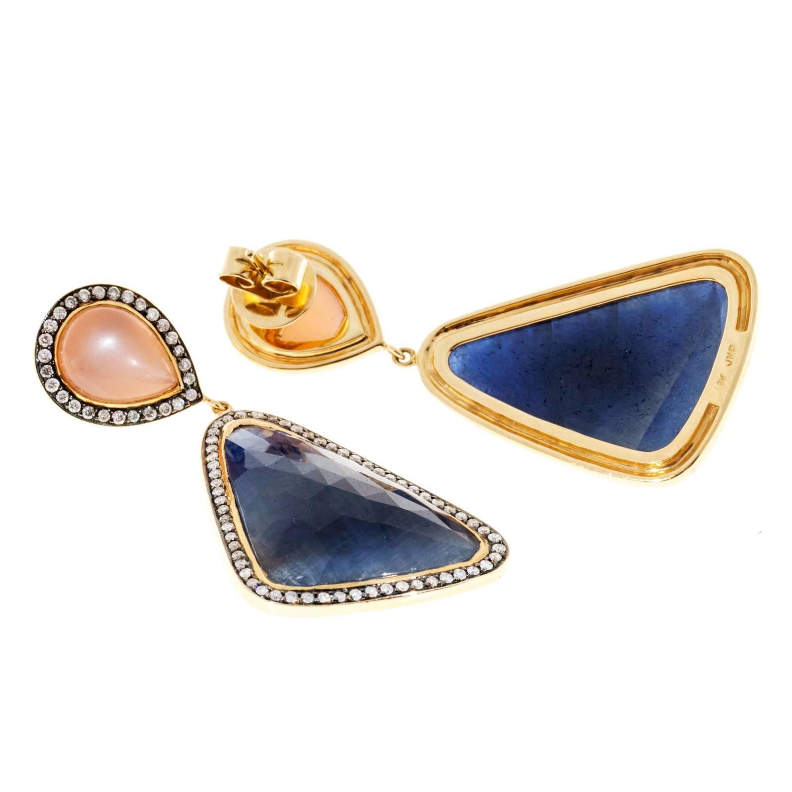  Designer 18k yellow gold dangle earrings with peach Moonstones and rose cut Sapphire slices from the designer JMP, surrounded by full cut diamonds. 

2 custom cut Sapphires, approx. total weight 12.00cts, 24.80 x 17.12 x 4.69mm 
2 pear cabochon