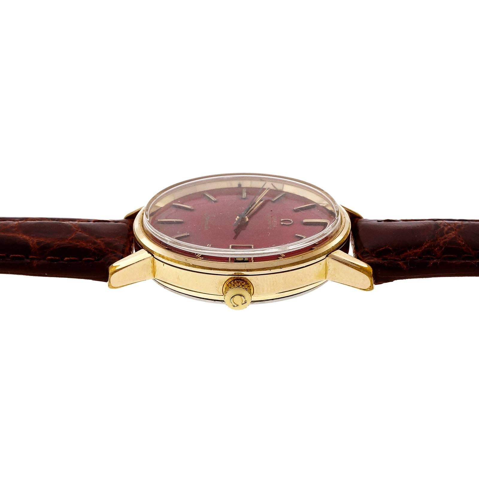 gold watch with red dial