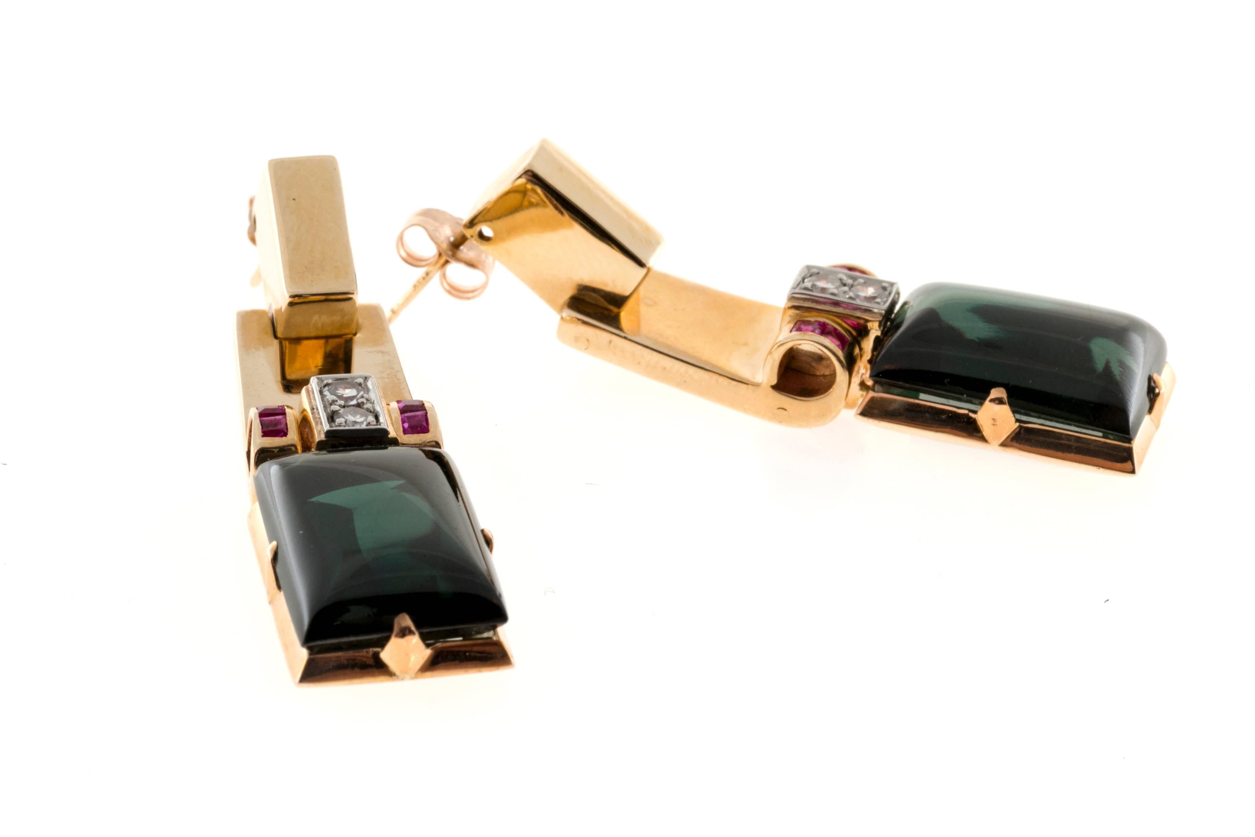 Ruby Diamond and Green Tourmaline set in a rose gold dangle earring.

2 Emerald cut Cabochon cut deep green Tourmaline, approx. total weight 25cts, VS, 16 x 11.2 x 7.5mm
8 bright red square Rubies, approx. total weight .40cts, VS
4 single cut