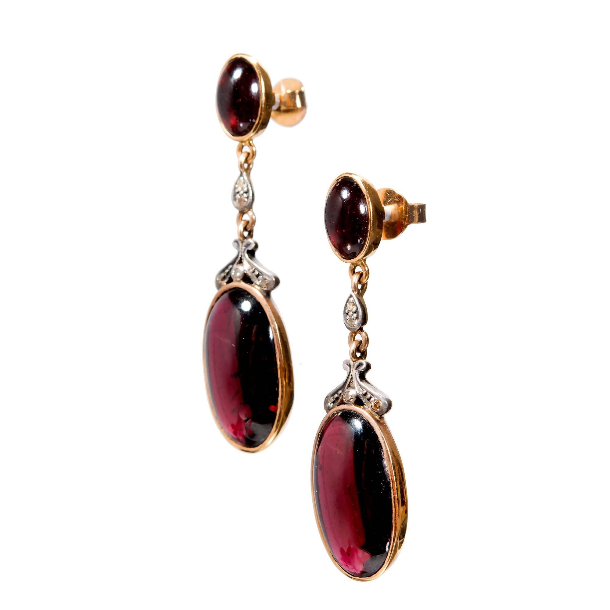 Circa 1930 Garnet and Diamond 18k rose gold and silver hand done bezels and bead set diamonds.

2 oval reddish Garnets, approx. total weight 2.00cts, SI1, 8.65 x 5.63 x 3.09mm
10 full cut diamonds, approx. total weight .10cts, J – K, SI
2 oval