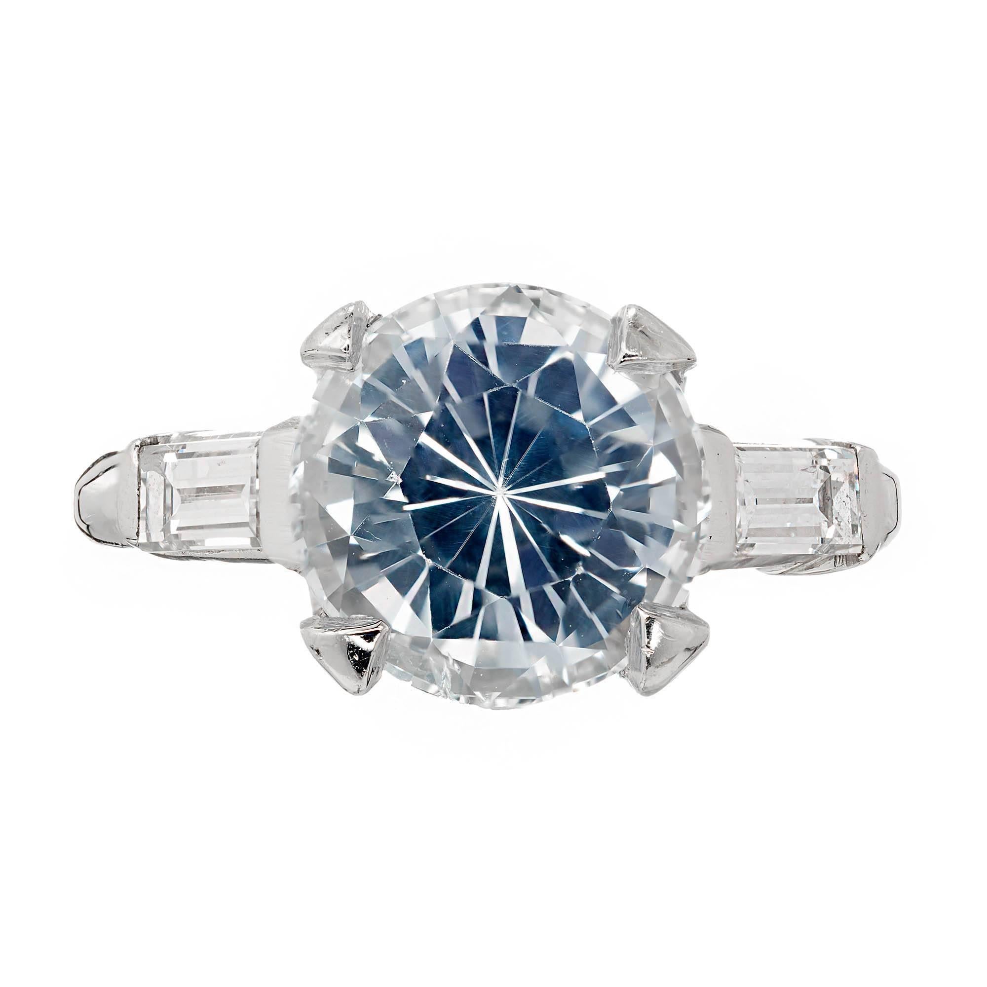 GIA certified natural light blue round Sapphire with 2 side baguette diamonds in Platinum engagement ring setting.  circa 1940.

1 round European cut very light blue Sapphire, approx. total weight 3.93ct, VS, natural color, simple heat only, GIA
