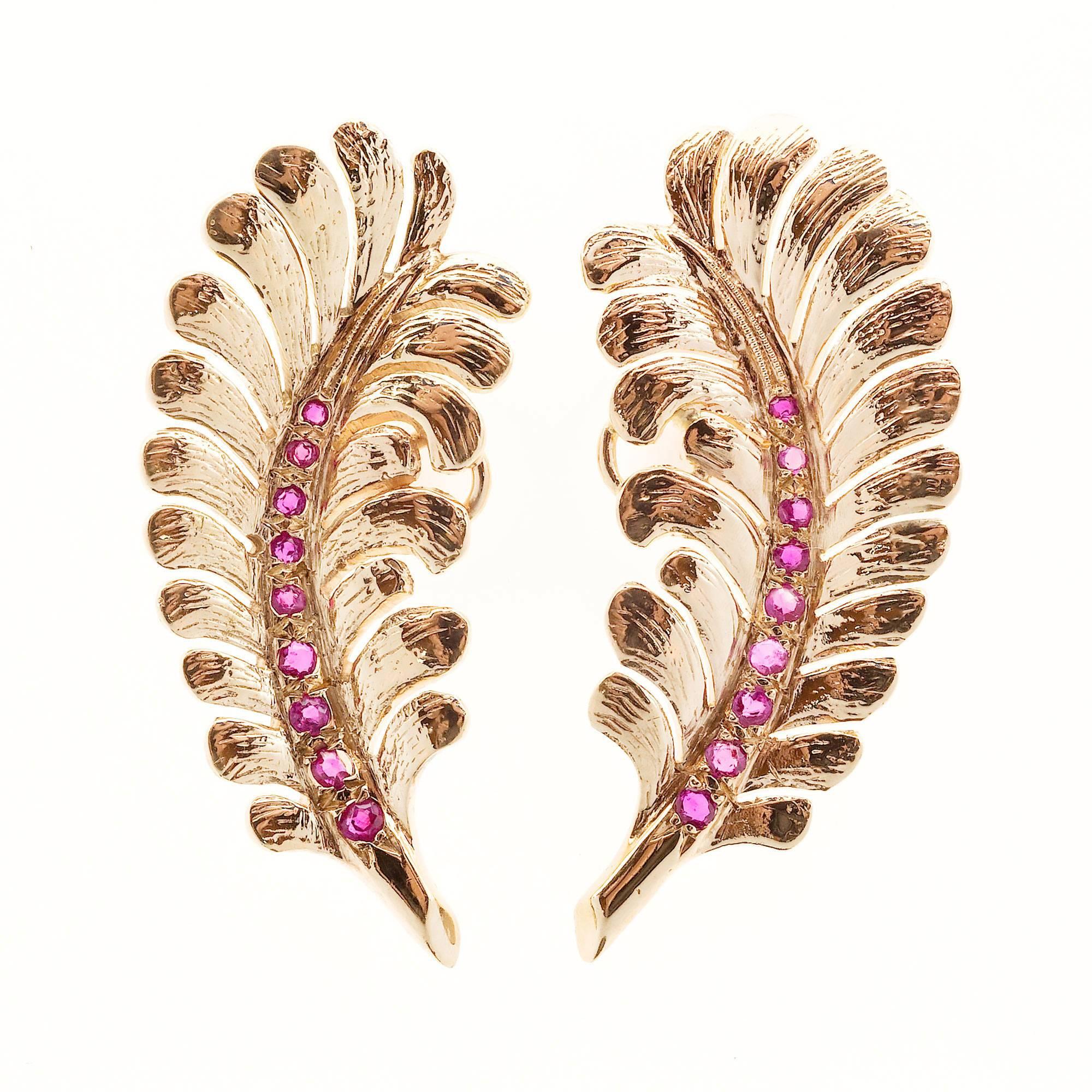 Authentic Tiffany & Co. 1950 to 1960 feather design earrings with left and right designs set with beautiful bright red Rubies. Excellent condition. Looks great on the ear.

18 natural genuine bright red Rubies, approx. total weight .22cts, VS
Top