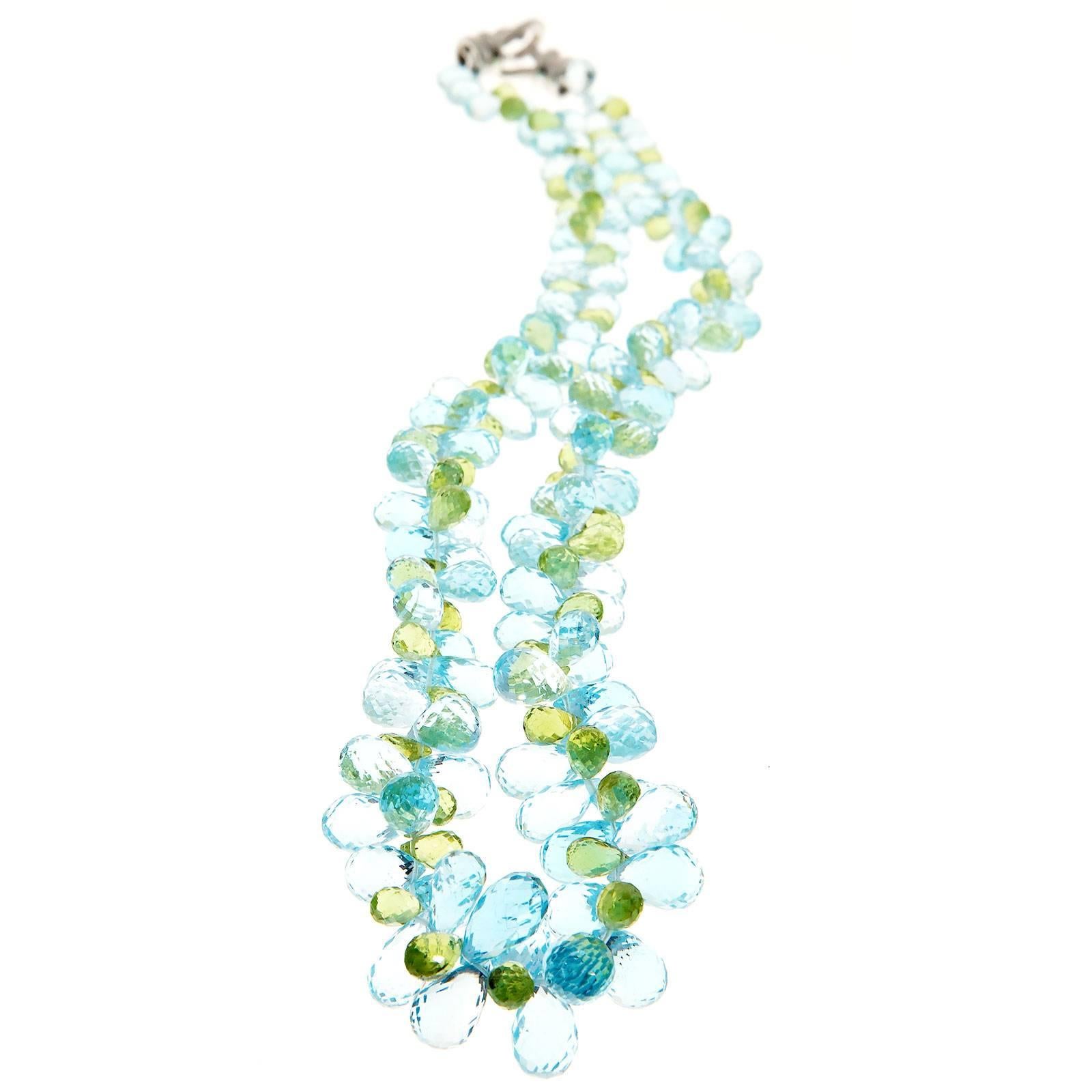 Genuine natural stone graduated briolette necklace. Bright blue Topaz and Peridot.

Approx. 180 Briolette cut bright blue Topaz 342.00cts 7 x 4.5mm to 11 x 7mm    
69.2 grams    
Total width: 11 x 20mm or .46 x .80 inch
Length: 18 inches   