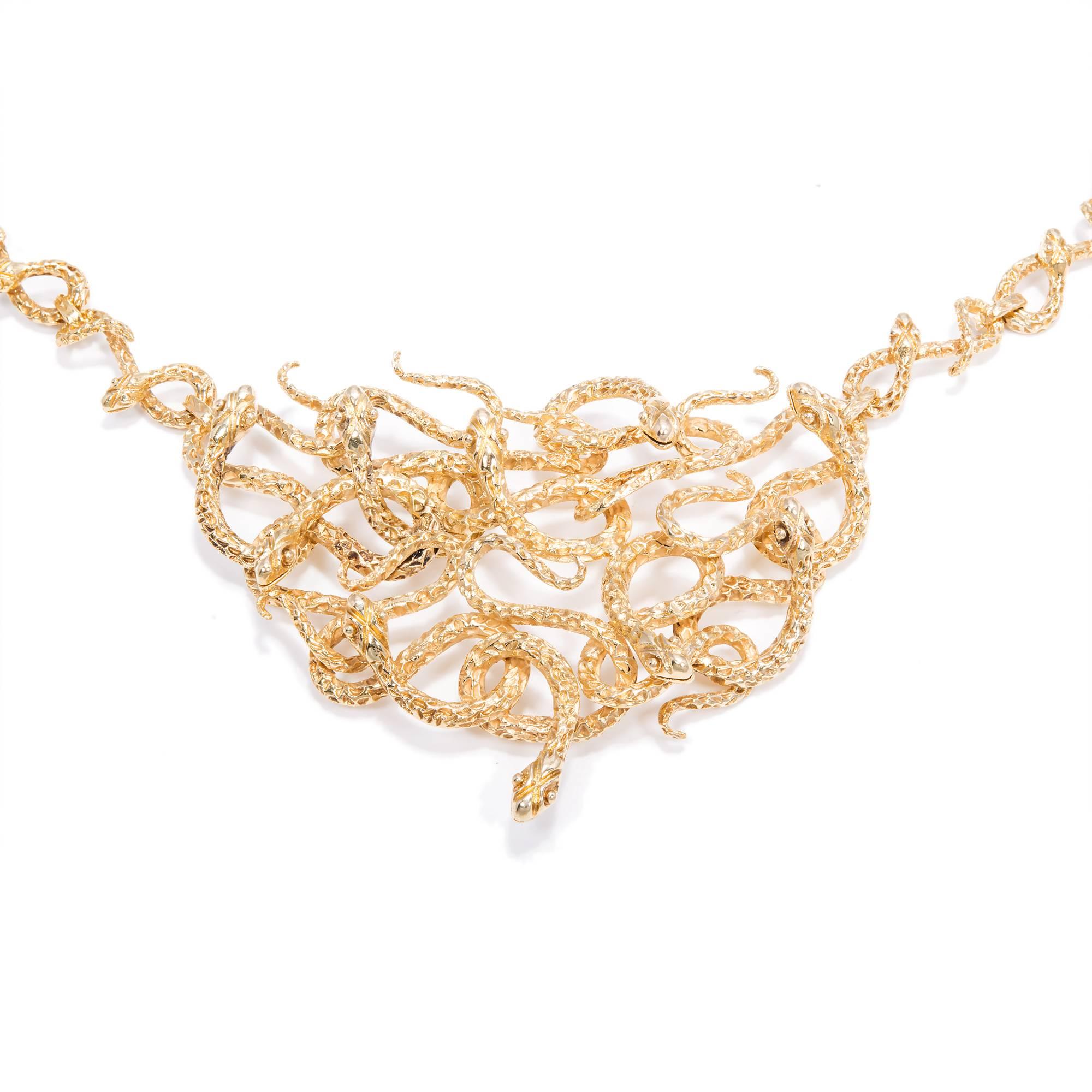Mid-century Medusa intertwined snake necklace in solid 18k gold. Textured serpents. Both the center section and the entire chain are end to end snakes.

18k yellow gold
Tested: 18k
Stamped: 750
Hallmark: 838
76.4 grams
Center section top to