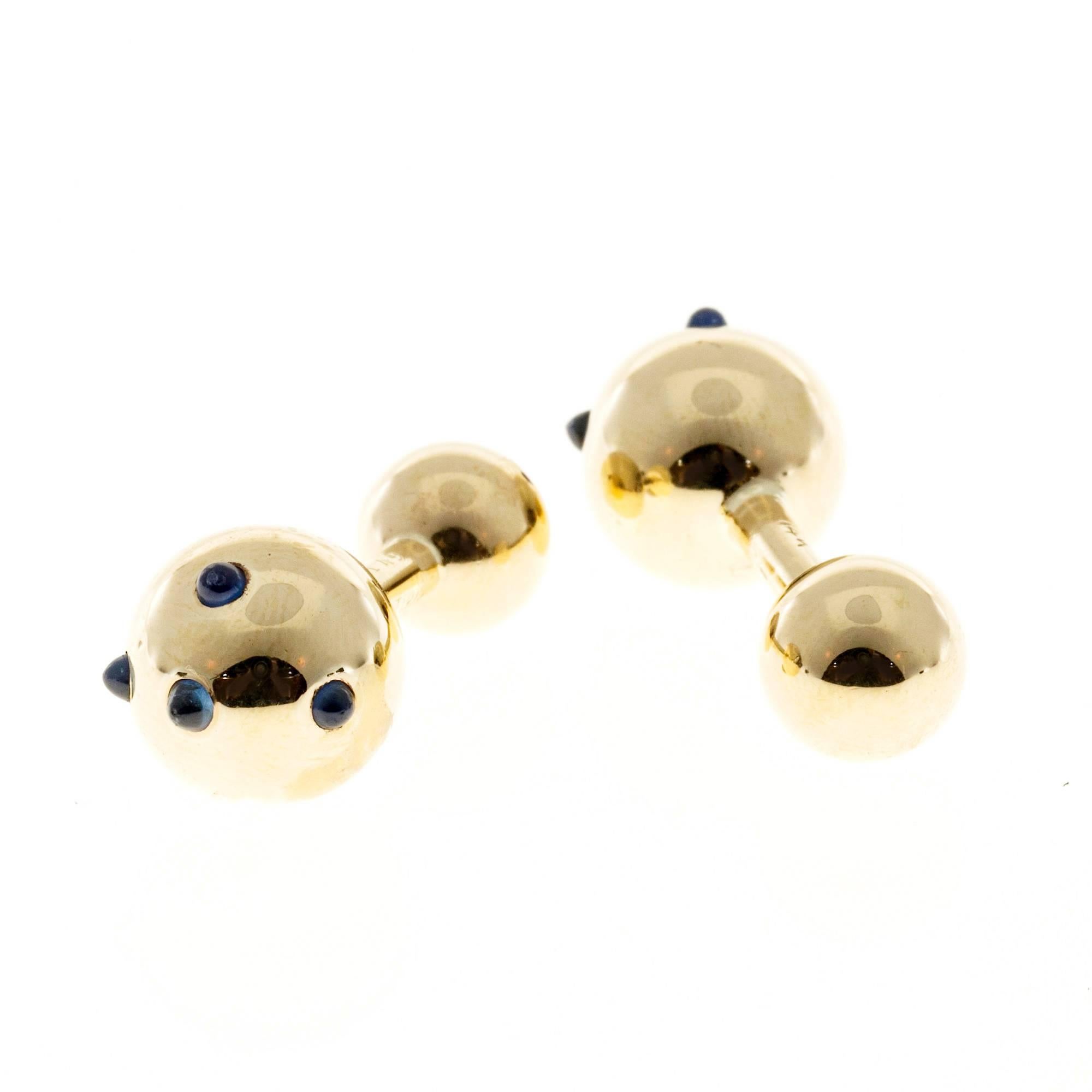 Cartier 1960-1969 Cartier barbell cufflinks in 14k yellow gold with cabochon Sapphires.

10 round cabochon blue Sapphires, VS, 2mm
14k yellow gold
Tested and stamped: 14k
Hallmark: 11149 Cartier
10.6 grams
Bar Bells: Large – 12.5mm – Small: