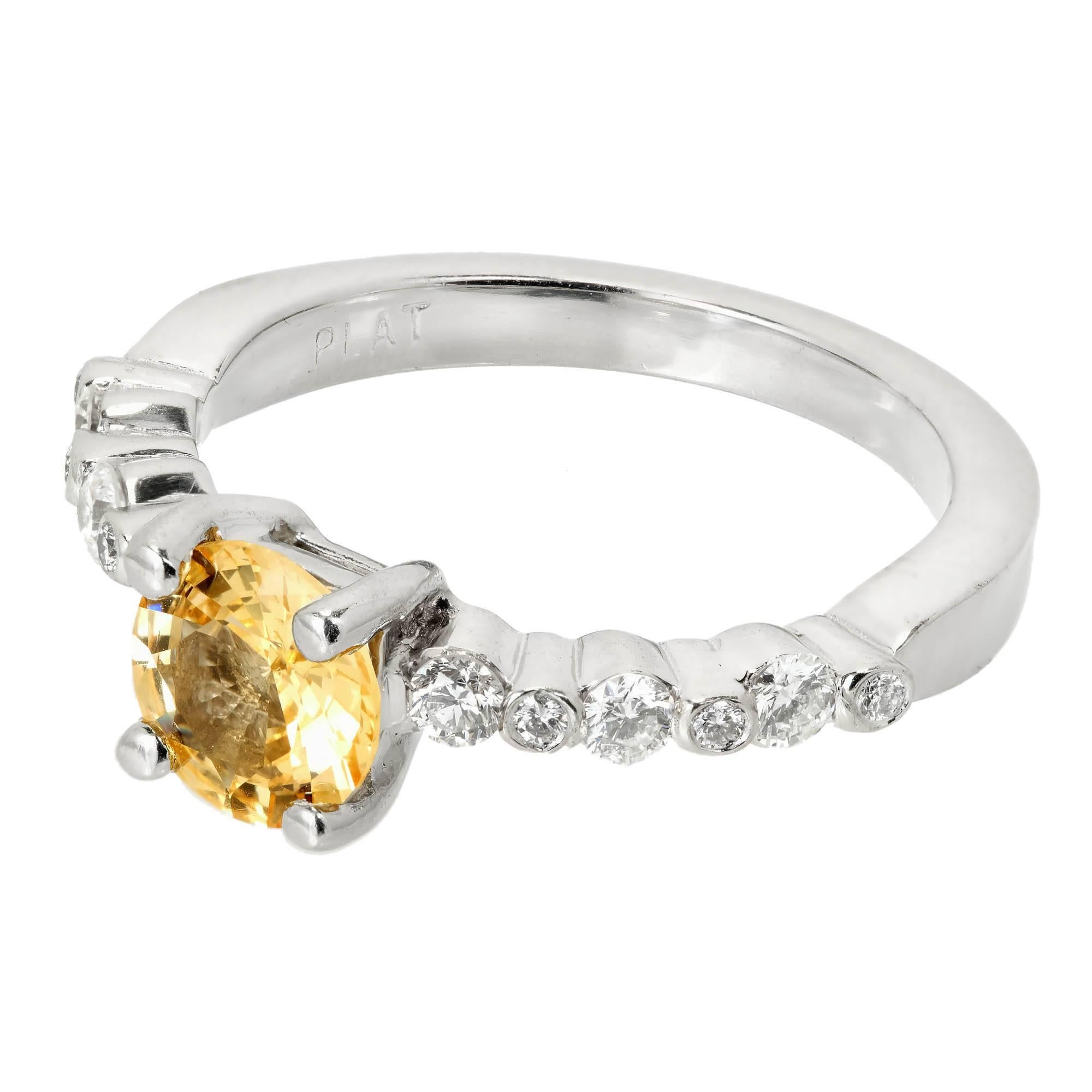 Natural custom cut round yellow Sapphire engagement ring with round cut diamond accents in a solid Platinum setting.  

1 modified brilliant cut natural fancy yellow round Sapphire, approx. total weight 1.05cts, VS, 6.48 x 6.54 x 3.24mm, natural no