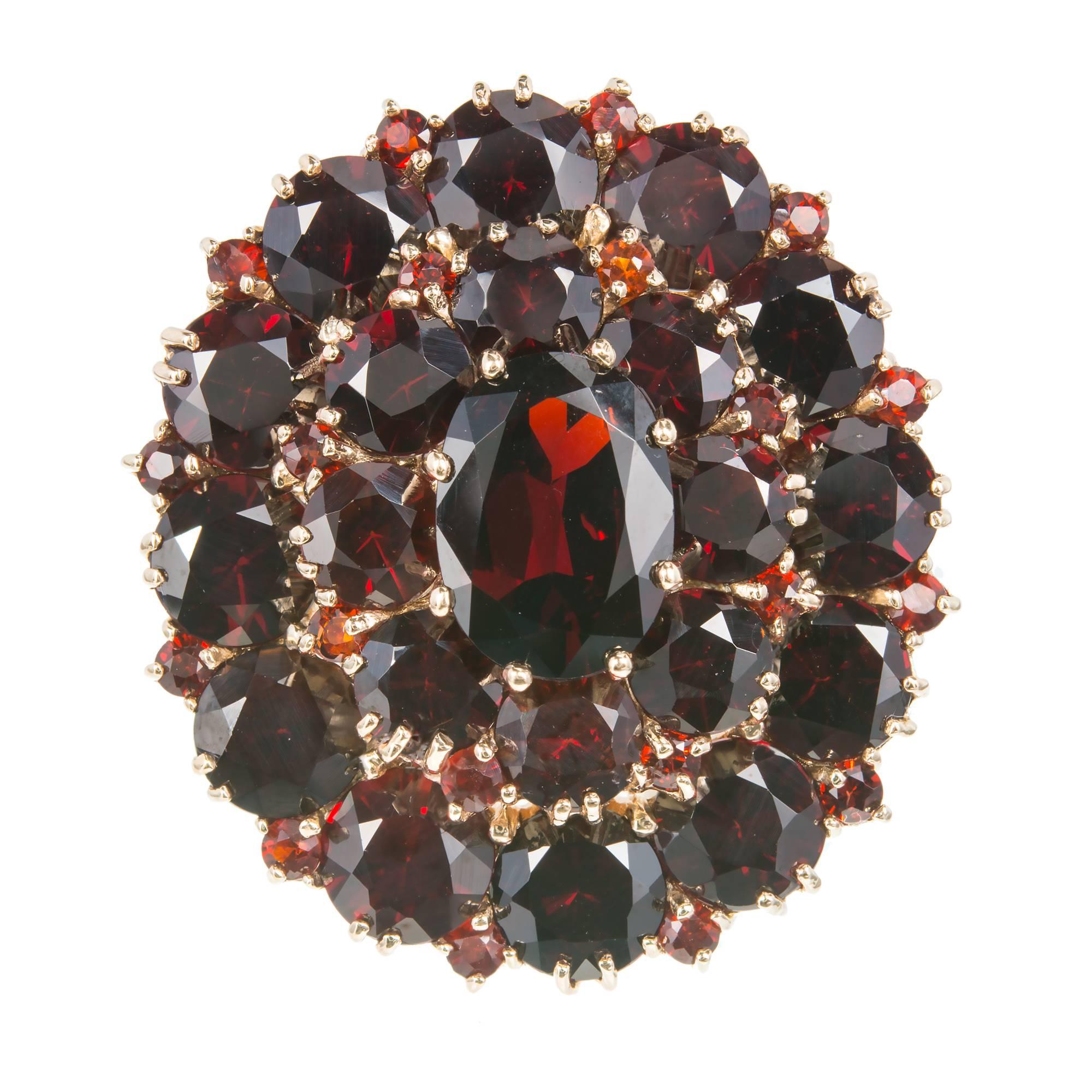 Large top vintage 1950 Garnet cluster cocktail ring in 10k yellow gold.  

Approximately 20.00cts total.
1 oval Garnet, approx 11.00 x 8.00mm
20 round Garnets, 2mm
Size 9 and sizable
10k yellow gold
Tested and stamped: 10k
Hallmark: PDN
14.3
