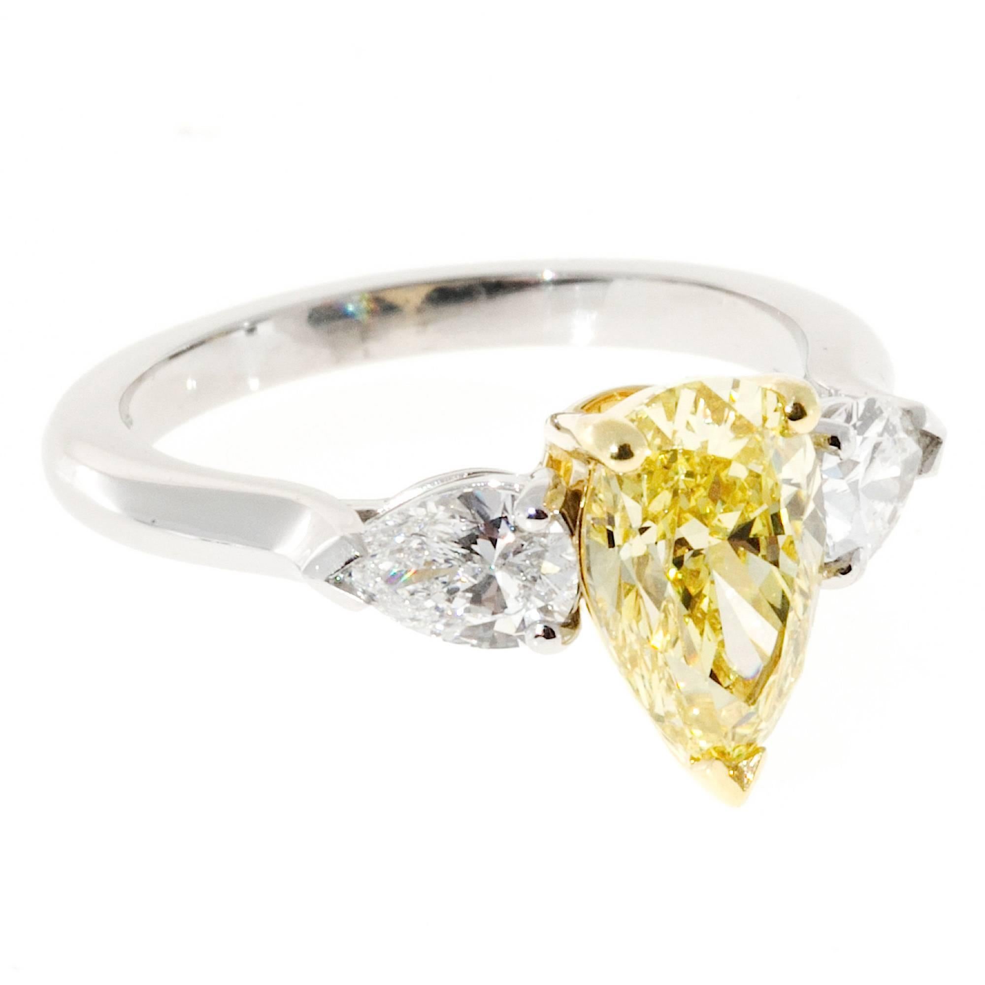 Fancy intense yellow pear shaped diamond flanked by two white pear shaped diamonds. The center diamond is Ideal cut. 18k yellow gold center setting with a platinum shank. The ring was designed by Peter Suchy Workshop to show off the beauty of the