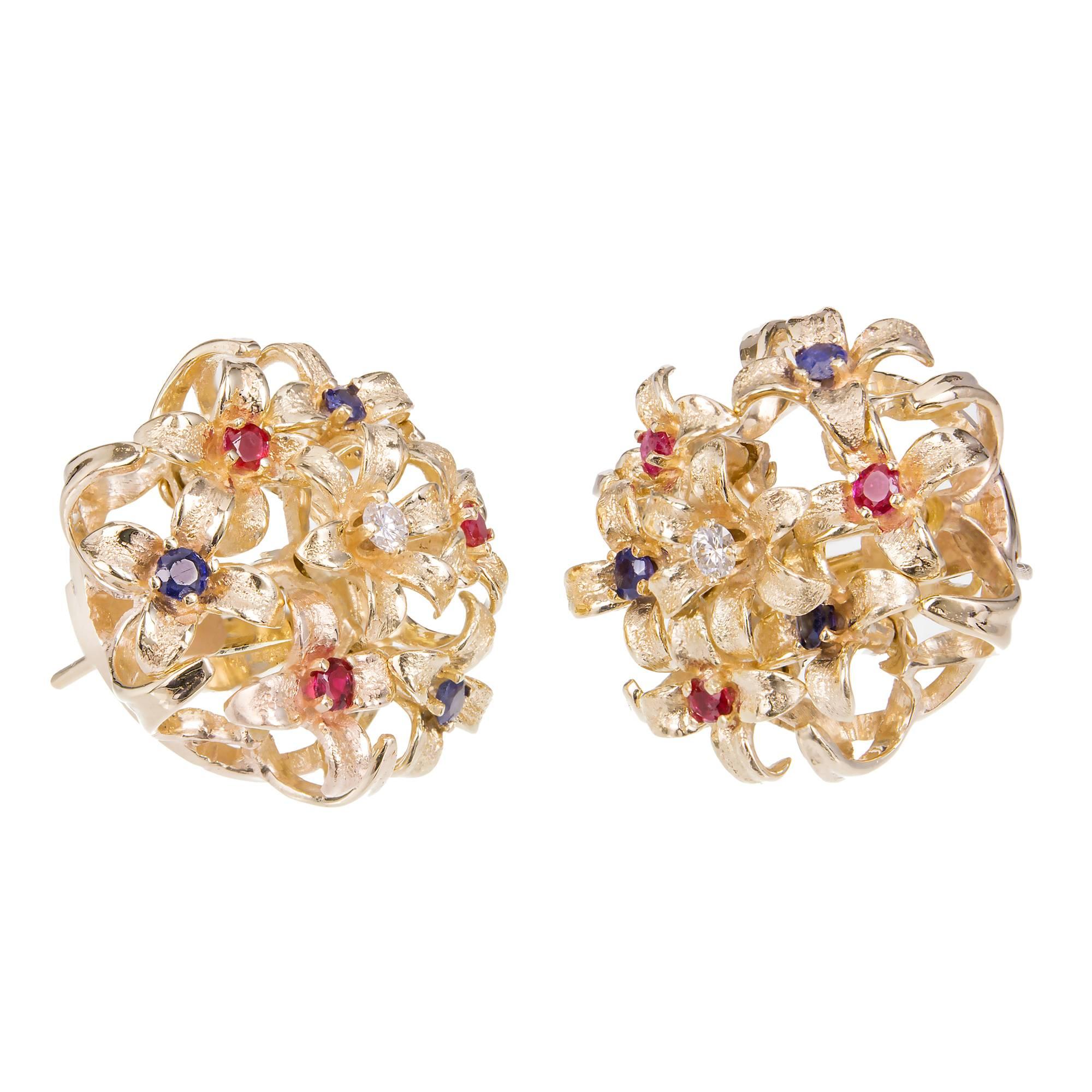 1950-1960 En Tremblant flower earrings set with round Sapphires, Rubies and Diamonds in a flower 14k yellow gold setting. Clip and post style.

6 round blue Sapphires, 2mm  approx total weight. .30ct
6 round red Rubies, 2mm  approx total weight