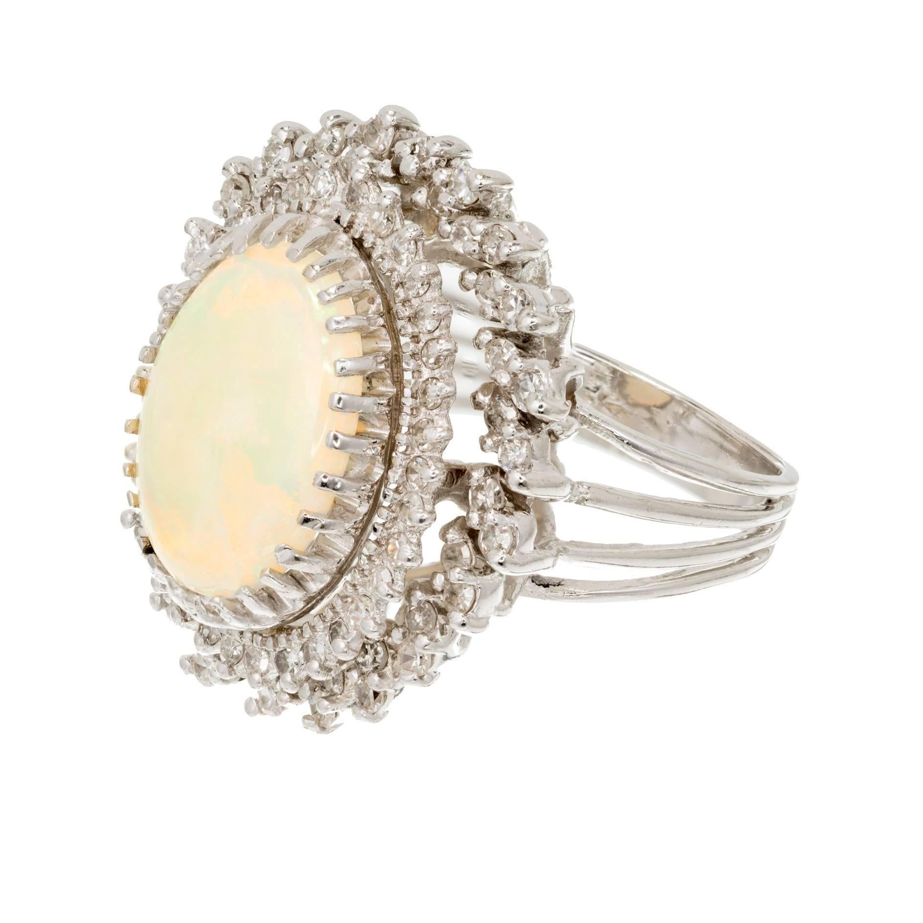 1950s large opal and diamond 14k white gold dinner style cocktail ring. 4.50ct oval well-polished Opal with great color flash surrounded by 3 rows of full cut diamonds.

1 white, with blue green orange flash natural color Opal, approx. total weight